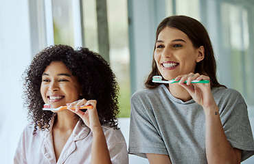 Image showing Toothbrush, oral care and women friends doing a dental, health and wellness morning routine together. Happy, smile and interracial females brushing their teeth for mouth hygiene in the bathroom.