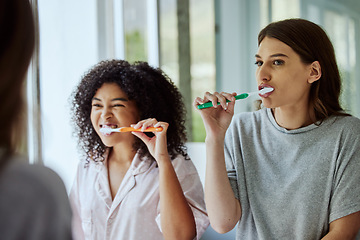 Image showing Toothbrush, dental hygiene and women friends doing a self care, health and wellness routine together. Happy, smile and interracial females doing oral care while brushing teeth in the bathroom at home