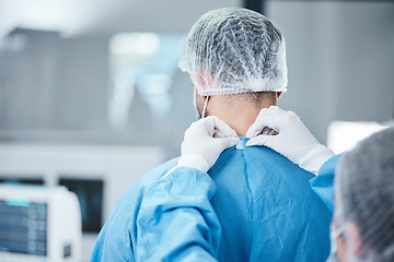 Image showing Surgeon, uniform and theatre clothes for surgery, operation or medical healthcare. Nurse helping doctor with safety scrubs in emergency operating room, hospital and wellness support, medicine or risk