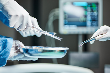 Image showing Doctors hands, surgery team and tools in icu, hospital or healthcare with tweezers, bullet or metal. Surgeon, health and emergency theater with scissor, bowl or ppe for safety, medical work or clinic