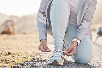 Image showing Woman, hands and shoelace for mountain runner, outdoor workout and fitness in summer in countryside. Running adventure, sneakers and tie lace for safety, speed and balance in road training for health