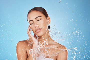 Image showing Woman skincare, hand or water splash face on blue background studio in healthcare wellness, Brazil hygiene maintenance or bathroom grooming. Beauty model, shower or wet water drop for facial cleaning