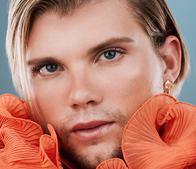 Image showing LGBT, fashion and portrait and gay man with orange clothes, creative beauty or androgynous style. Transgender, queer or bisexual model with makeup, skincare glow and face cosmetics on blue background