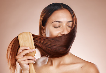 Image showing Hair care, beauty and brush with a woman brushing after salon, hairdresser or shampoo treatment in studio. Face of aesthetic female model grooming clean hair in studio for health and wellness mockup