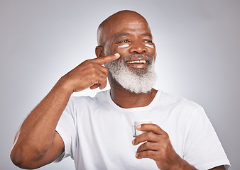 Image showing Black man, beauty and skincare with facial cream on skin with dermatology and cosmetics for healthy glow. Face of senior male with sunscreen or lotion container on grey studio background for wellness