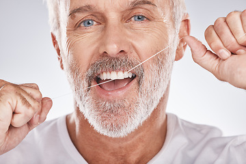 Image showing Dental, floss and face of senior man in studio isolated on a gray background. Portrait, cleaning or elderly male model with product flossing teeth for oral wellness, healthy gum hygiene or tooth care