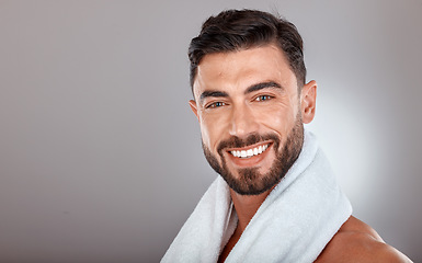 Image showing Man with towel, beauty and face with skincare, hygiene and self care portrait against studio background. Grooming, skin and glow with cosmetic mockup, facial wellness and clean teeth with smile