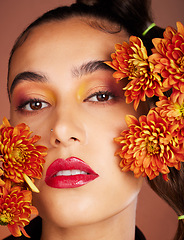 Image showing Makeup, beauty or woman in studio with flowers for art fashion and natural facial cosmetics for self care. Face portrait, orange plants or girl model with red lipstick, eyeshadow and glowing skin