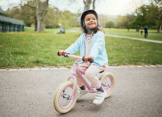 Image showing Cycling, thinking and child on a bike in the park, outdoor activity and learning in New Zealand. Sport, happiness and girl kid playing on bicycle ride in the neighborhood street or road in childhood