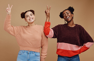 Image showing Diversity, peace sign and women friends in studio with hand gesture, smile and happiness on brown background. Fashion, cosmetics and black woman with girl for relax, lifestyle and happy together