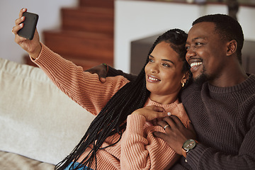 Image showing Black couple, phone selfie and love while together on home couch with care and happiness in a happy marriage. Young man and woman with a smile for social media while bonding in an apartment lounge