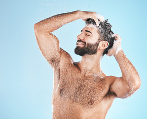 Image showing Hair, shampoo and cleaning with a man in studio on a blue background to take a shower for hygiene. Water, skin and relax with a male washing for haircare or keratin treatment in the bathroom