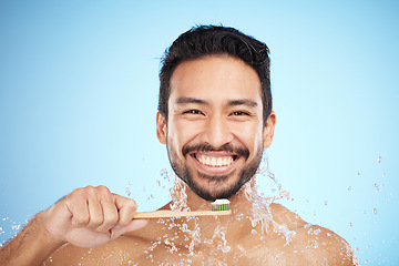 Image showing Water splash, portrait or man brushing teeth in studio with toothbrush for white teeth or dental healthcare. Bamboo wood, sustainable or happy person cleaning or washing mouth with a healthy smile