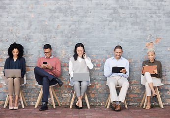 Image showing Business people, line and sitting relax with technology for interview meeting, recruitment or company hiring. Human resources, employees happy and working on laptop, tablet or smartphone in studio