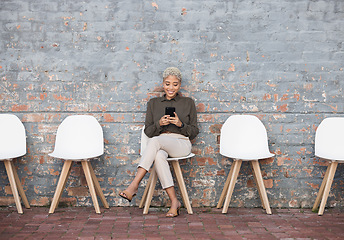 Image showing Recruitment, job search and woman on brick wall sitting in line with phone for opportunity, hr email and success. Smartphone, waiting room and black people on social media for career networking app