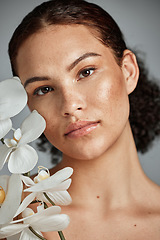 Image showing Face portrait, skincare and woman with orchid in studio isolated on a gray background. Floral makeup, organic cosmetics and female model with flowers for healthy skin treatment, wellness and beauty