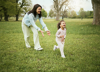 Image showing Mother, girl child and running in park with love, bonding or happiness on grass field for care on holiday. Mama, kid and playful quality time to relax outdoor, woods or backyard garden for nature fun