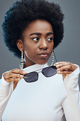 Image showing Fashion, beauty and black woman with sunglasses in studio for cosmetics, makeup and luxury style. Fashion model, designer brand and confident girl with stylish accessories, trendy and edgy jewellery