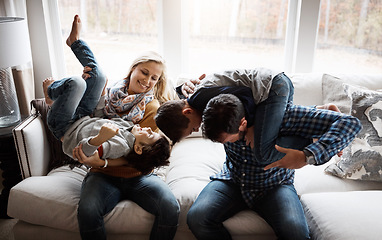 Image showing Playful, funny and family on the sofa with energy for fun, playing and bonding in their house. Relax, happy and parents with crazy children to play wrestle on the couch during quality time in a home