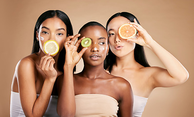 Image showing Skincare, diversity and women with fruit, cosmetics and dermatology with friends on brown studio background. Face, vitamin c or ladies with natural beauty, girls and nutrition with healthy lifestyle