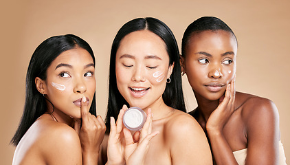 Image showing Skincare, women and face cream in studio for wellness, grooming and hygiene against brown background. Friends, beauty and lotion for girl group with different, facial and skin product while isolated