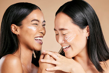 Image showing Happy, beauty and skincare women with cream for face isolated on a beige studio background. Wellness, smile and Asian model friends with sunscreen for love of cosmetics and dermatology on a backdrop