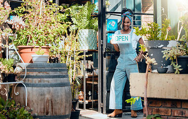 Image showing Open sign, small business or black woman in flowers store with advertising board in organic nursery. Welcome, agro manager or happy entrepreneur with a smile opening a floral or plants retail shop