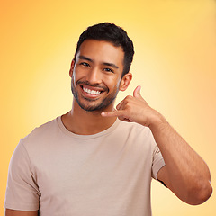 Image showing Portrait, call me hands and man in studio isolated on a yellow background. Face, fashion and happy male model with cool hand gesture for shaka sign, symbol or emoji for communication and connection.