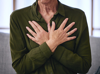 Image showing Senior woman, health and hands on chest for breathing exercise, cardiology care and wellness at home. Healthcare, heart support and elderly female on sofa holding body to breathe, relax and calm