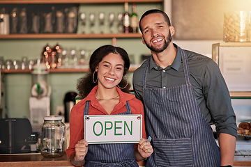 Image showing Portrait, small business or couple with open sign to welcome sales in a cafe or coffee shop with hospitality. Restaurant or managers with a happy smile with message on board after opening a store