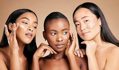 Image showing Face cream, skincare and women in studio for wellness, grooming and hygiene against brown background. Friends, beauty and lotion for girl group with different, facial and skin product while isolated