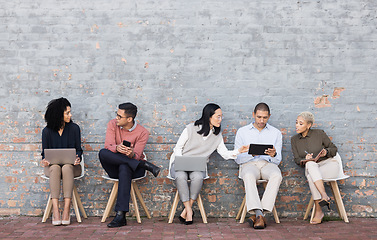 Image showing Diversity, worker interview line and discussion with technology for meeting, recruitment or company hiring. Human resources, happy employees and speaking together on laptop, tablet or smartphone