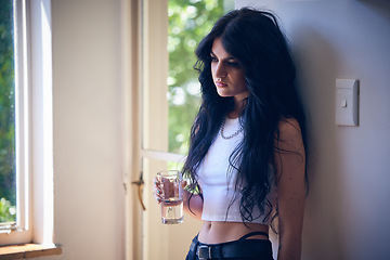 Image showing Mental health, depression and sad woman thinking with water, stress and anxiety in a house. Depressed, lonely and goth girl with a drink, emotional and comtemplating problems in the lounge of home