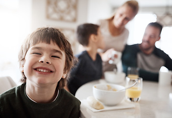 Image showing Happy, breakfast and portrait of boy with family for at kitchen table for food, child development and bonding. Quality time, smile and happiness with son at home for diet, morning and nutrition
