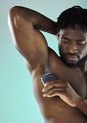 Image showing Grooming, hygiene and black man with armpit deodorant isolated on a blue background in studio. Skincare, cleaning and African model with a product for body odor and morning routine on a backdrop