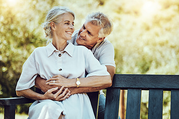 Image showing Love, nature and husband hugging his wife from behind while sitting on an outdoor bench in the park. Happy, care and elderly couple embracing on a romantic date together in a green garden in Canada.