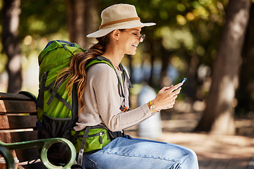 Image showing Woman, backpack or phone in travel, sightseeing or adventure in nature park, trees forest or Canada woods. Smile, happy or tourist on mobile technology for gps map, location or hiking path research