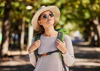 Image showing Sunglasses, woman and travel in nature, adventure and tourist with smile, thinking and enjoy adventure. Female, tourism and lady with eyewear, road trip and walking for health, summer and happiness