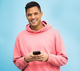 Image showing Happy man, portrait or phone typing on isolated blue background on social media, fashion app or city internet. Smile, person or student model on mobile communication technology by Brazil wall mockup