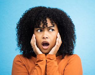 Image showing Wow, surprise and thinking with a black woman in shock standing on a blue background in studio. Omg, confused and idea with an attractive young female looking shocked or surprised indoor