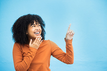 Image showing Black woman, wow face and pointing hands in studio for news, announcement or notification by blue background. African gen z girl, young model and fashion with surprise hand sign with excited laugh