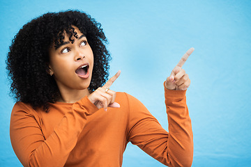 Image showing Black woman, surprise and pointing hands in studio for news announcement, gossip notification and blue background. African gen z girl, young female model and fashion for wow, hand sign and happiness