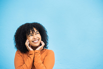 Image showing Thinking, happy and mockup with a black woman on a blue background in studio for branding or product placement. Idea, smile and mock up with an attractive young female looking thoughtful on space