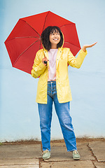 Image showing Rain, black woman and umbrella in a city for travel, having fun and solo trip on wall background. Weather, happy and girl traveler enjoying rainfall, happy and smile for journey, experience and joy