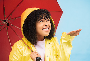 Image showing Black woman, umbrella or hand catching rain on isolated blue background in Brazil city. Person, student or checking for weather water drops in rainfall anxiety, curious or wondering facial expression