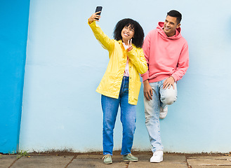 Image showing Happy couple, peace sign or phone selfie on isolated blue background for social media, profile picture and travel vlog. Smile, man and black woman bonding for on mobile photography technology in city