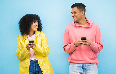 Image showing Friends, phone and smile for social media, conversation or communication against a blue studio background. Happy man and woman smiling for networking, 5G connection or chatting on mobile smartphone