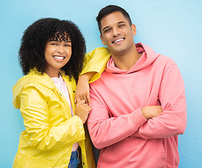 Image showing Couple of friends, portrait and happy people on isolated blue background in fashion, afro hair trend and cool style clothes. Smile, man and black woman bonding with arms crossed or weather raincoat