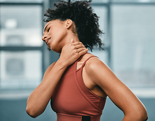 Image showing Fitness, neck pain or black woman in gym with pain or injury after workout exercises or body training alone. Emergency, African girl or injured sports athlete holding sore muscle after bad accident