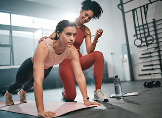 Image showing Personal trainer, fitness and stopwatch with a black woman coaching a client in a gym during her workout. Health, exercise or training and a female athlete doing a plank with her coach recording time